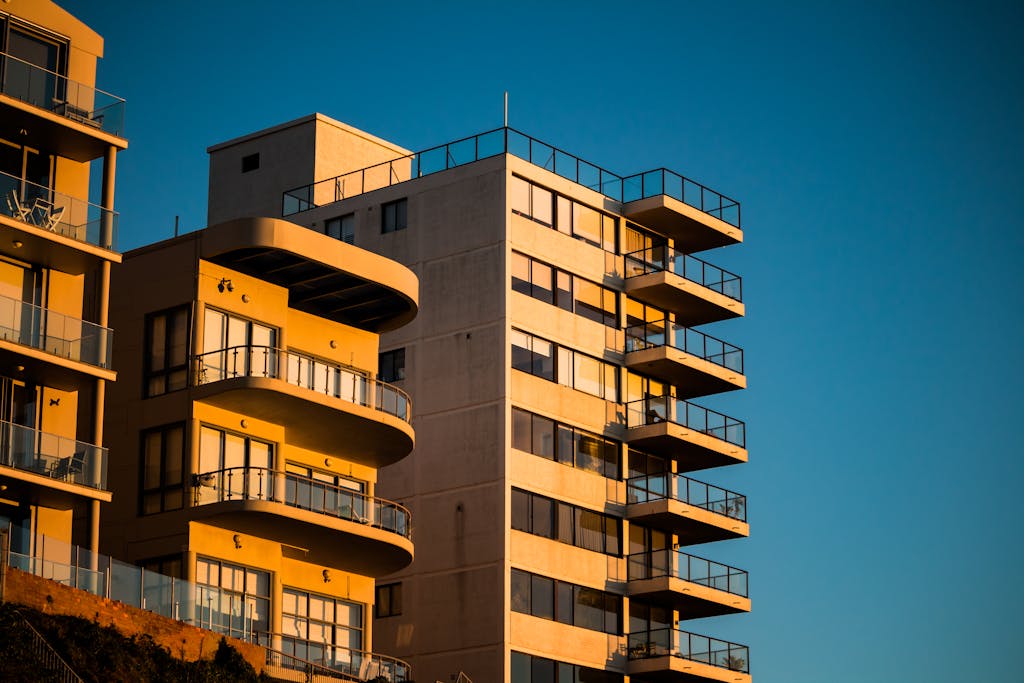 Modern apartment buildings with unique facades illuminated by sunset lighting.